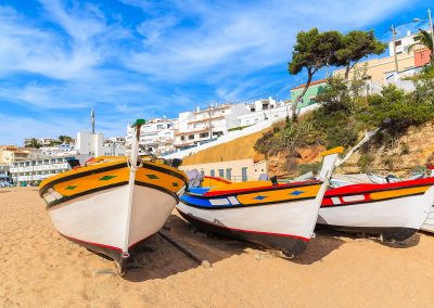 Traditional colourful fishing boats on beach in Carvoeiro village, Algarve region, Portugal